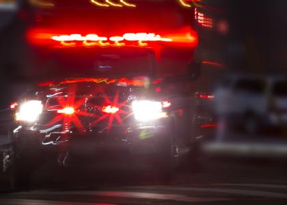 An ambulance racing through dark streets