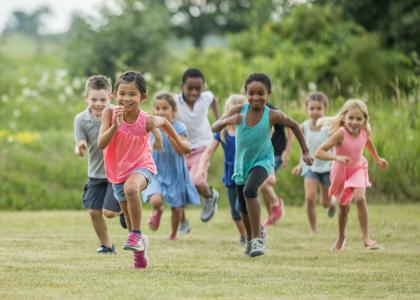 many children running on a large grass lawn