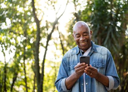 Middle-aged man smiling and using cell phone