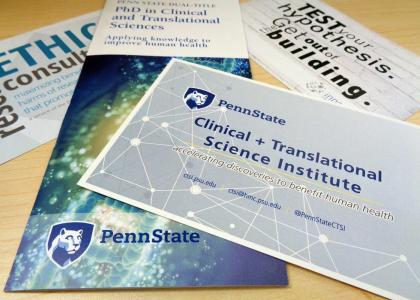A pile of brochures advertising Penn State Clinical and Translational Science resources lays on a desk. 