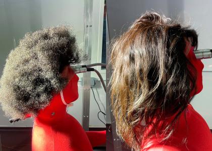 Side-by-side photos of a thermal manikin, connected to a power source, wearing tightly curled (left) and straight (right) human hair wigs.
