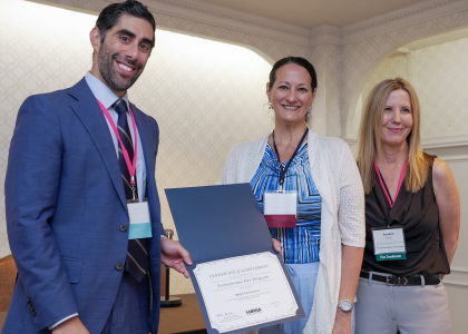 Three people post with certificate