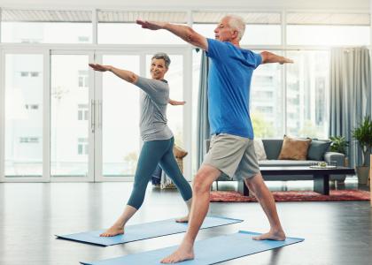 An older man and older woman doing yoga