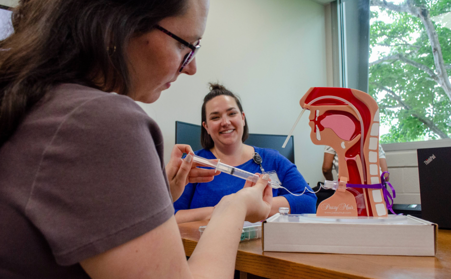 Graduate student works with a practice tracheostomy