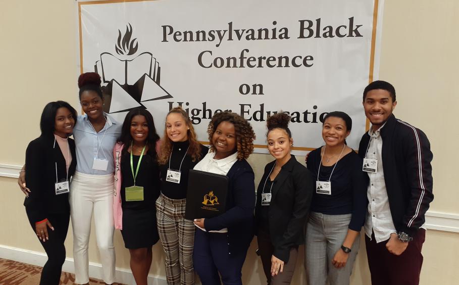 Students posed in front of PA Black Conference on Higher Education sign