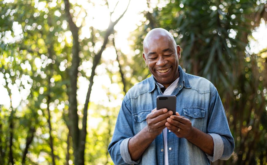 Middle-aged man using a cell phone and smiling