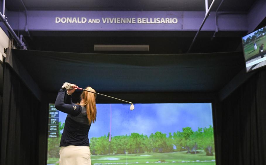 Female student at the top of her golf swing in the Donald and Vivienne Bellisario GTRC portal