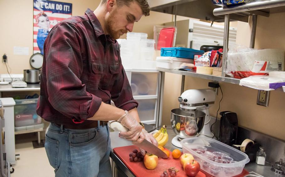 Male student prepping food in the kitchen lab. 