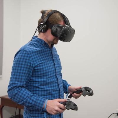 HDFS grad student using a virtual reality headset in a lab