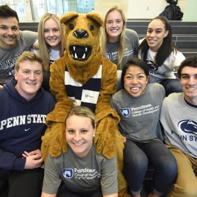Students sitting with Nittany Lion