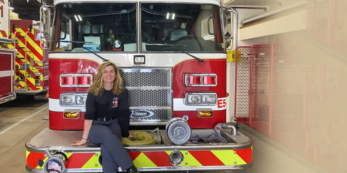 Sarah Kollat sitting on the bumper of a fire engine