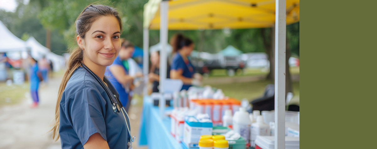 A woman is outside and looking at the camera and smiling. 