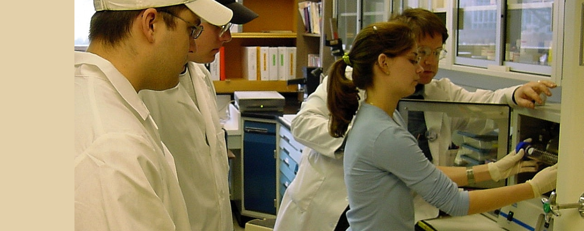 Students practice using a lab machine with the supervision of a faculty member.