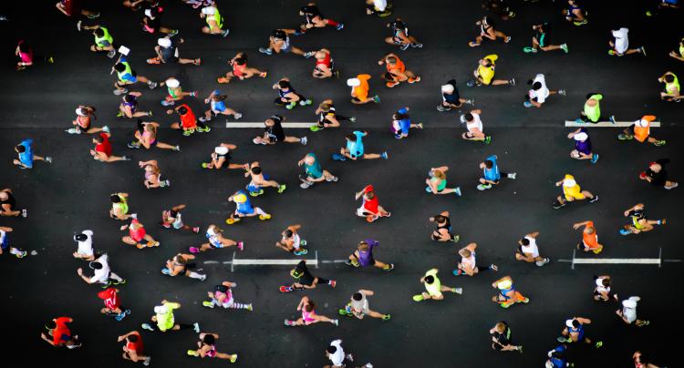 overhead shot of people running a marathon on a road